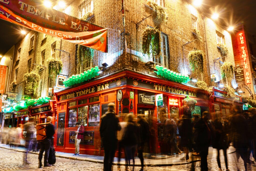 Lively night scene at the iconic Temple Bar in Dublin, showcasing St. Patrick's Day celebrations.
